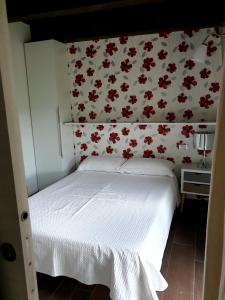 1 dormitorio con 1 cama y papel pintado con motivos florales en One bedroom appartement with shared pool and wifi at Montalto delle Marche, en Montalto delle Marche