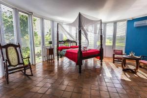 a bedroom with a bed in a room with windows at Villa de 2 chambres a Sainte Rose a 500 m de la plage avec vue sur la mer piscine privee et jardin clos in Sainte-Rose