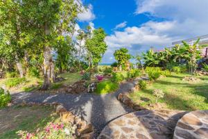 a path through a garden with trees and flowers at Villa avec piscine et vue sur la mer - Sainte Rose in Sainte-Rose