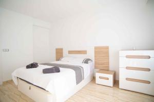 ein weißes Schlafzimmer mit 2 Betten und einer Kommode in der Unterkunft Beautiful Two Bedroom Apartment next to the beachfront in La Horadada