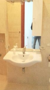 uma casa de banho com um lavatório branco e um espelho. em One bedroom appartement with wifi at Montegiordano 9 km away from the beach em Montegiordano