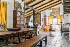 a living room with a wooden table and yellow curtains at 4 bedrooms villa with private pool enclosed garden and wifi at Valverde de Leganes in Valverde de Leganés