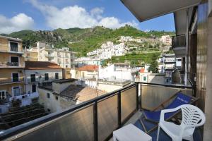 a balcony with a chair and a view of a city at Spacious Apartment in Maiori with Sea View - 110 m² in Maiori