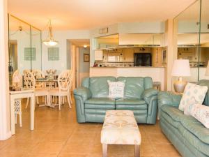uma sala de estar com um sofá azul e uma cozinha em Sand Dollar Condominiums em Daytona Beach Shores