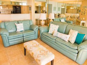 uma sala de estar com dois sofás azuis e uma mesa em Sand Dollar Condominiums em Daytona Beach Shores