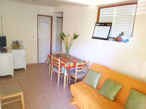 sala de estar con sofá y mesa en Maison de 2 chambres avec vue sur la mer terrasse amenagee et wifi a Les Anses d'Arlet, en Les Anses-dʼArlet