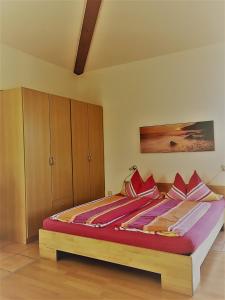 1 dormitorio con 1 cama grande con almohadas rojas en Appartement Joli, en Bernau am Chiemsee