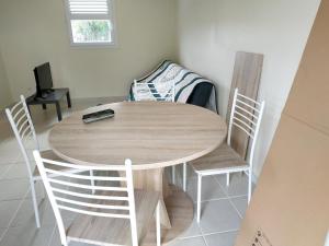 una mesa de madera y sillas en una habitación en Studio avec jardin clos et wifi a Le Lamentin a 5 km de la plage en Le Lamentin