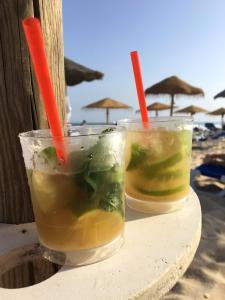 two drinks sitting on a table on the beach at Comfortable Apartment Tavira + Terrace in Tavira