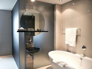 un baño con bañera y lavabo en Colosseum Hotel, en Ciudad del Cabo 31 fotos más