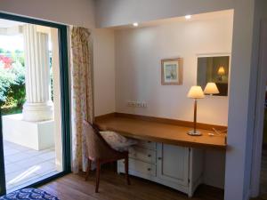 Un escritorio con una lámpara y una silla en una habitación. en Appartement cosy à Saint-André-des-Eaux de 47 m² avec jardin, en Saint-André-des-Eaux 9 fotos más