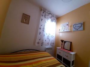 ein kleines Schlafzimmer mit einem Bett und einem Fenster in der Unterkunft Appartement charmant à Bandol 30 m² avec vue sur la mer. in Bandol