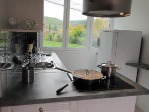 a kitchen with a stove with pots and pans on it at SANDRE, FISH AND GITES in Lanzac