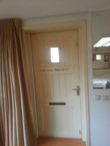 Een deur met een bord erop dat zegt dat de wereld me pijn kan doen. bij Appartement Blom in Dordrecht