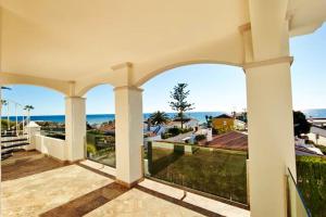 un patio al aire libre con vistas al océano en 5 bedrooms villa with private pool jacuzzi and furnished terrace at Marbella, en Marbella