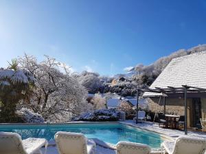 a swimming pool with chairs and a house at Villa spacieuse avec piscine à Aspin-en-Lavedan, vue montagne. in Aspin-en-Lavedan
