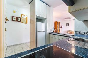 a kitchen with a refrigerator and a sink at Sea View Apartment in Benalmádena, Shared Pool in Benalmádena
