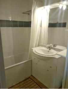 een witte badkamer met een wastafel, een bad en een douche bij Appartement de 2 chambres avec vue sur la ville piscine partagee et terrasse a La foux d'Allos in La Foux