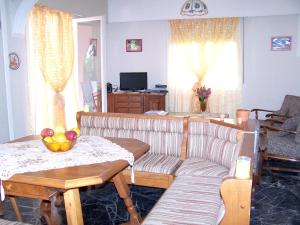 een woonkamer met een bank en een tafel bij 3 bedrooms house with enclosed garden and wifi at Kakovatos in Kakóvatos