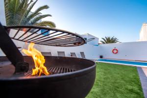 eine Feuerstelle im Hinterhof mit Pool in der Unterkunft Elegant Villa Playa Blanca with Pool in Playa Blanca