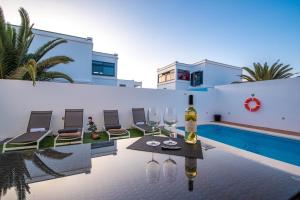 eine Villa mit Weingläsern und einem Pool in der Unterkunft Elegant Villa Playa Blanca with Pool in Playa Blanca