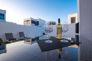 zwei Weingläser auf einem Tisch auf einem Balkon in der Unterkunft Elegant Villa Playa Blanca with Pool in Playa Blanca