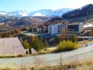 une vue aérienne sur un bâtiment avec des montagnes en arrière-plan dans l'établissement Charmant appartement à Enchastrayes 38 m² avec vue montagne, à Enchastrayes