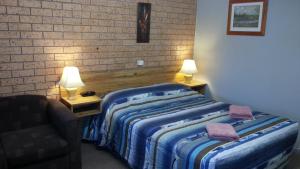 A bed or beds in a room at Three Ways Motel