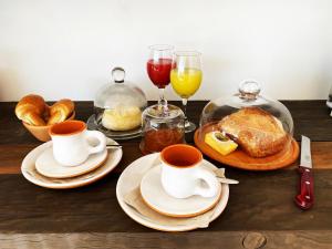 a table with cups and plates of food and drinks at Palcos de Apalta in Santa Cruz