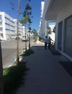 two people walking down a sidewalk next to a building at One bedroom appartement at Martil 300 m away from the beach with city view and wifi in Martil