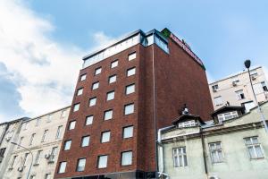 un edificio de ladrillo rojo con un reloj encima en Amsterdam Hotel en Belgrado