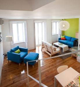 a living room with blue furniture and green walls at Graca LIGHT in Lisbon