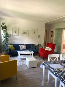 - un salon avec un canapé bleu et des fauteuils rouges dans l'établissement Apartment Ida, à Innsbruck