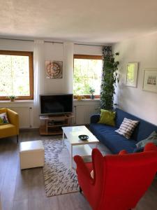 - un salon avec un canapé bleu et un fauteuil rouge dans l'établissement Apartment Ida, à Innsbruck