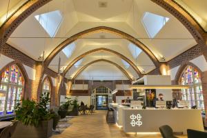 a lobby of a building with arches and windows at Onderwijshotel De Rooi Pannen Tilburg in Tilburg