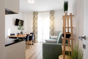 uma sala de estar com um sofá verde e uma mesa em Aosta Centre Apartments - Battaglione 10 em Aosta