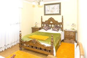 a bedroom with a wooden bed with a green blanket at Spacious House with Mountain View in Carboeiro de Francia in Martije