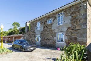 a car parked in front of a stone building at Spacious House with Mountain View in Carboeiro de Francia in Martije