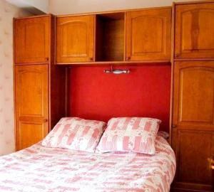 a bedroom with a bed with wooden cabinets at Appartement de 2 chambres a Villers sur Mer a 150 m de la plage in Villers-sur-Mer