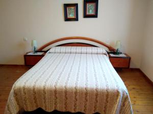 uma cama num quarto com 2 cómodas e 2 candeeiros em 2 bedrooms apartement at Llanes 200 m away from the beach with wifi em Llanes