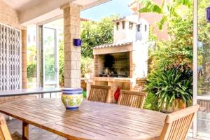 une table et des chaises en bois sur une terrasse avec une cheminée dans l'établissement Luxury Villa in Marratxí, Private Pool, à Palma de Majorque