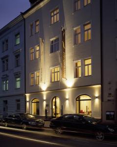 deux voitures garées devant un bâtiment dans l'établissement Design Merrion Hotel, à Prague