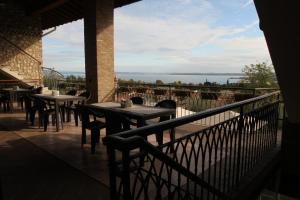 balcón con mesas y sillas y vistas al agua en Agriturismo Cascina Crocelle, en Padenghe sul Garda