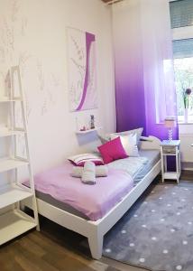 Un dormitorio con una cama con paredes moradas y una escalera en ELENA flat Lavendel Duisburg Zentrum, en Duisburg