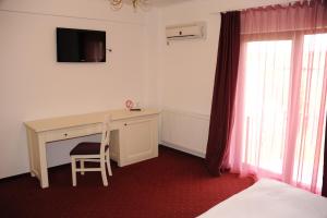 a room with a desk with a computer and a chair at Pensiunea Velvet in Iaşi