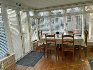 a dining room with a table and chairs and windows at Fourwinds B&B in March