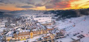 an aerial view of a town in the snow at sunset at Hotel Bania Thermal & Ski in Białka Tatrzańska