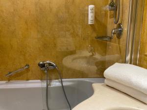 a bath tub sitting next to a toilet at Holiday Inn Cagliari, an IHG Hotel in Cagliari