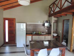 エル・チャルテンにあるMorena Apartのテーブルと白い冷蔵庫のあるキッチン