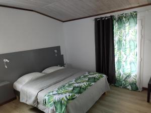 a bedroom with a bed and a large window at VILLA GRONDIN in Cilaos